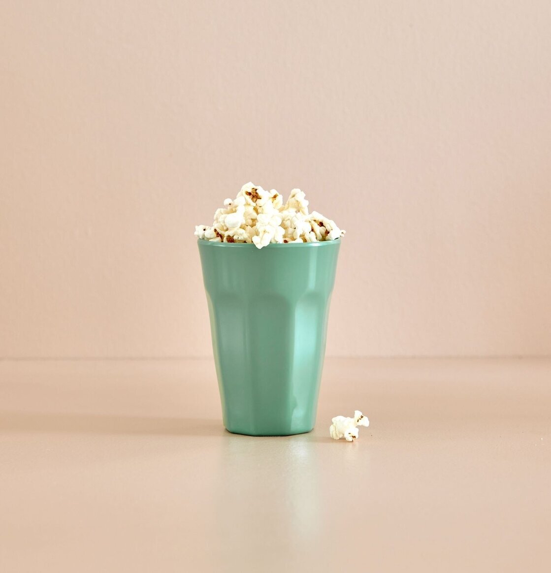 Mugg Latte Mint från Rice fylld med popcorn på ett bord
