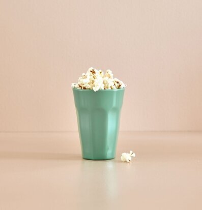 Mugg Latte Mint från Rice fylld med popcorn på ett bord