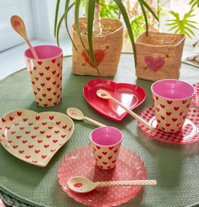 Bild av färgglad dukning med hjärtmönstrad melaminservis