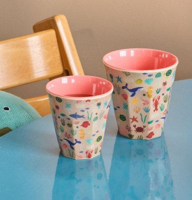 Bild på färgglada melaminmuggar med havsmotiv på blått bord