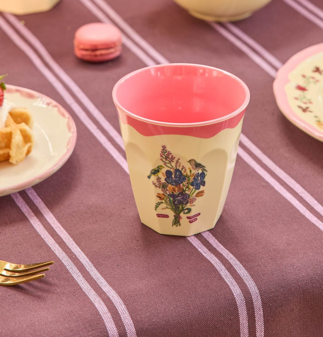 Bild av färgglad dukning med melaminmugg och blomsterdekor