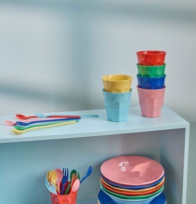 Foto: Färgglada melaminmuggar och bestick på hylla