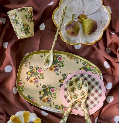 Foto: Blommig melaminservis på prickigt tyg ovanifrån