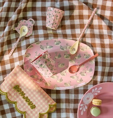 Foto av rosa dukning med svanmotiv på picknickduk