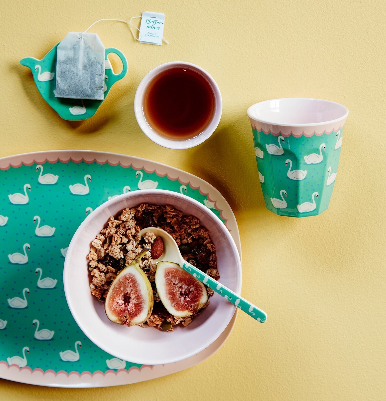 Mugg Swan Print från Rice på ett gult bord med matchande föremål